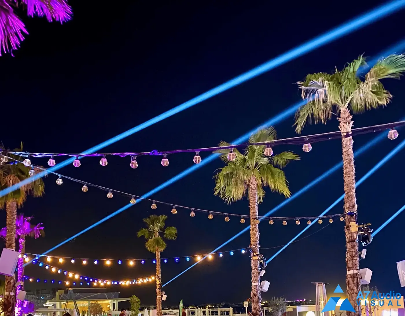 Blue event lighting beams above the palms at Five Palm Dubai