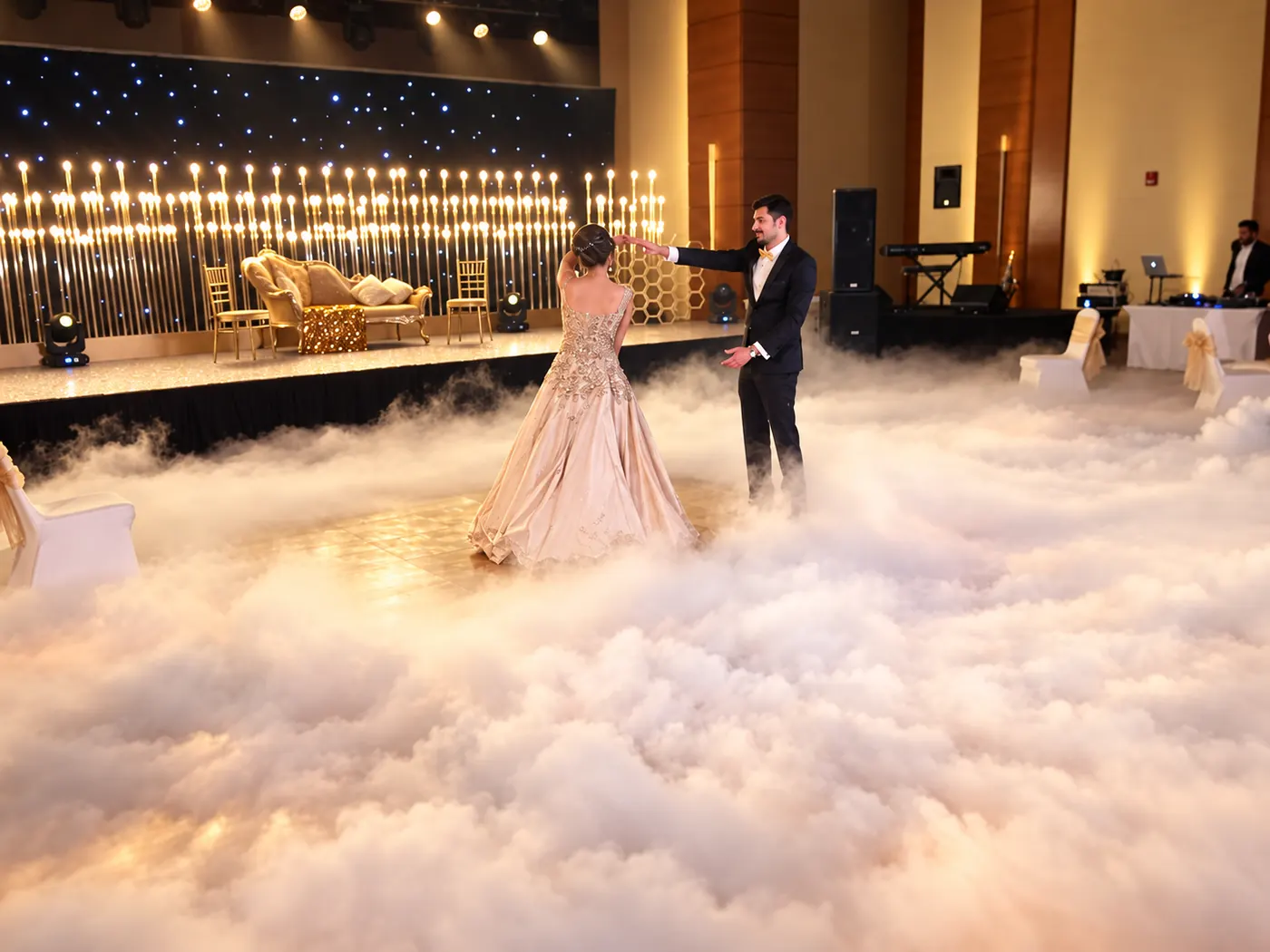A couple dancing through low fog at a wedding reception