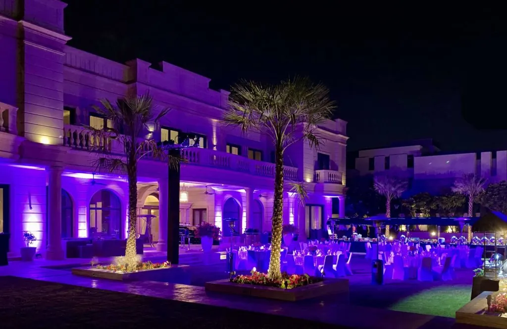 Outdoor venue illuminated with purple architectural uplighting